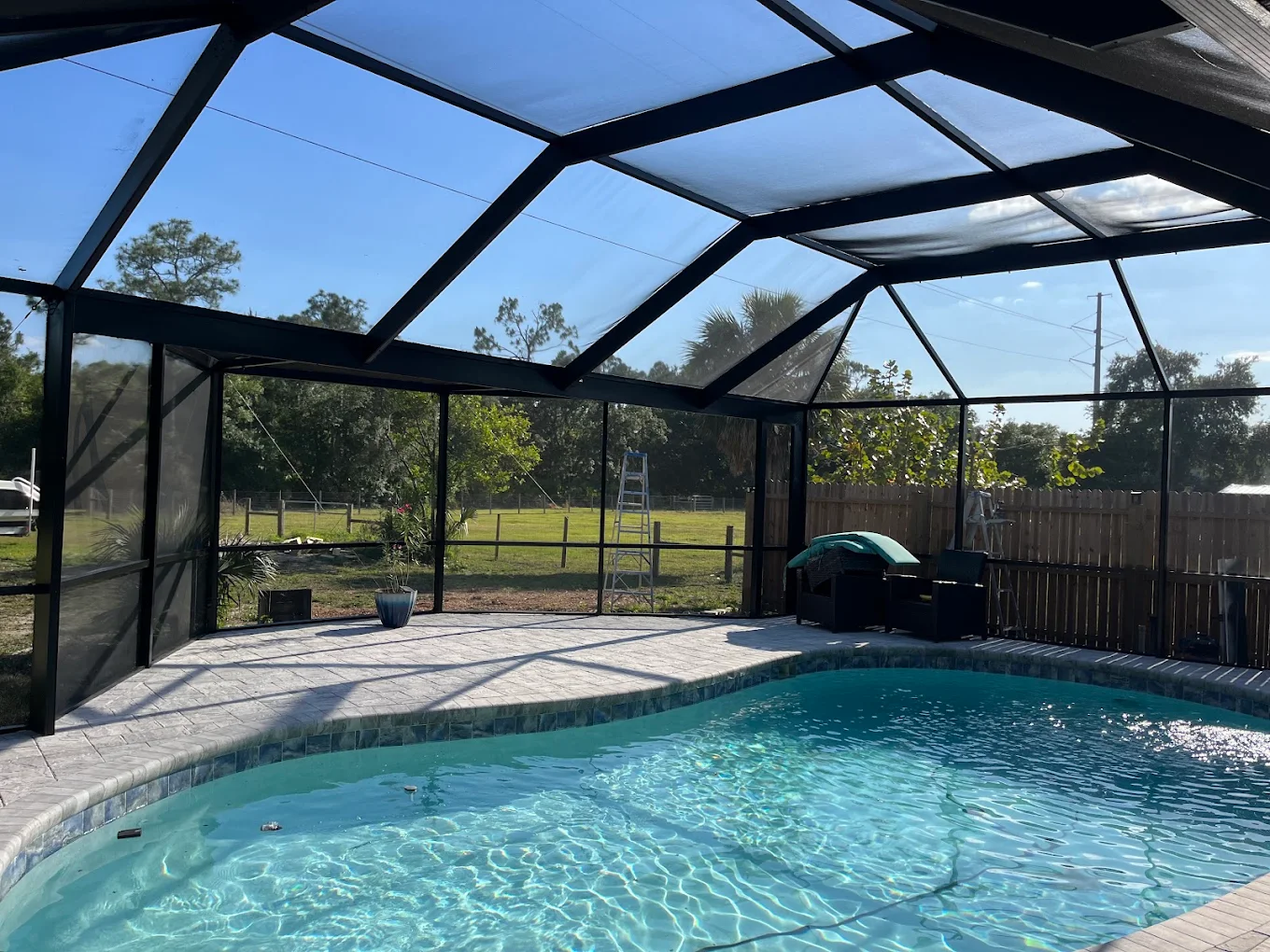 Screened-in swimming pool with clear blue water
